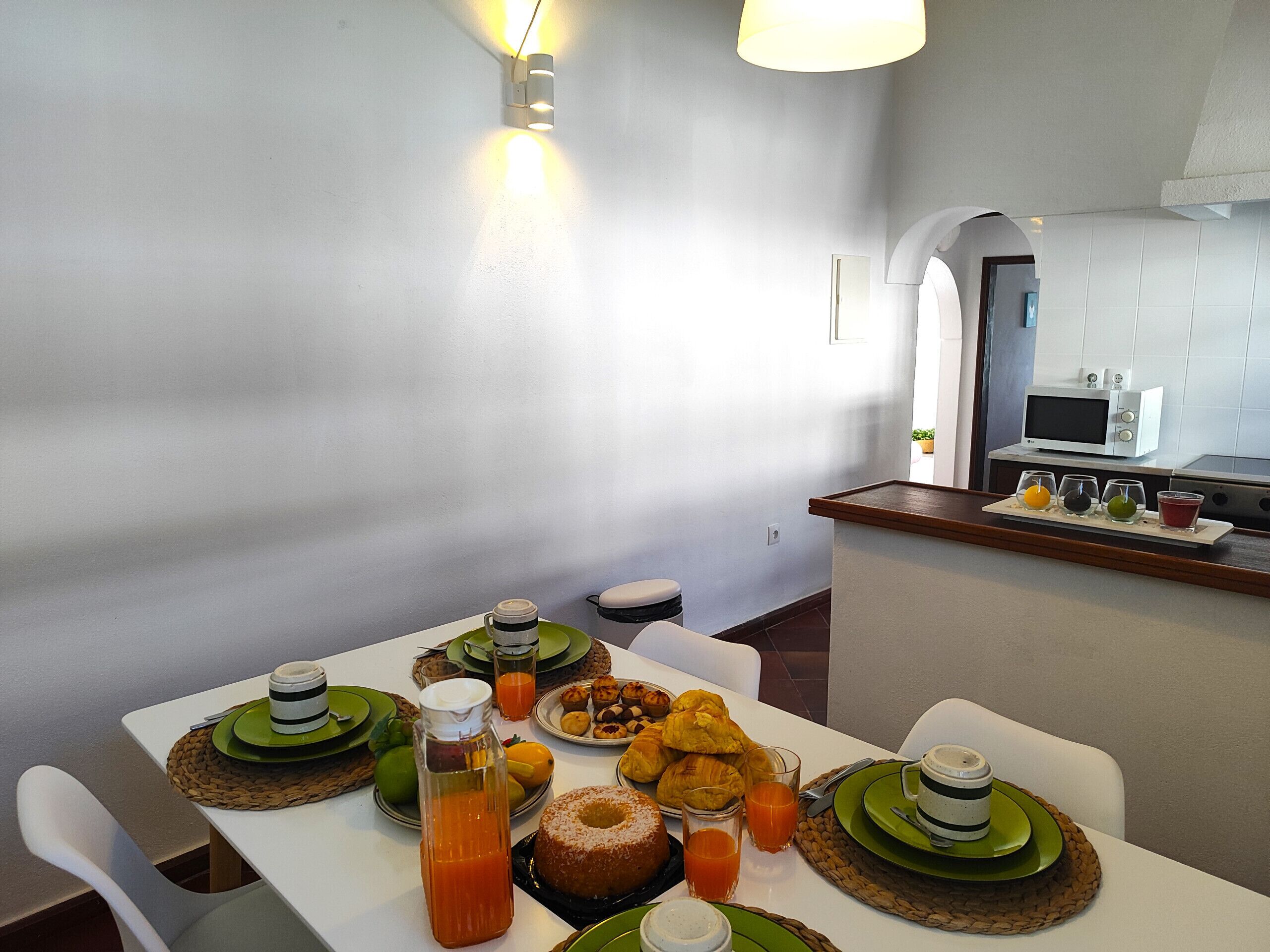 A breakfast table set with plates, glasses, and a variety of food items.