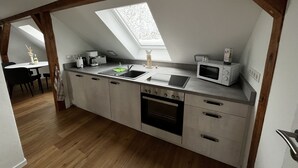 A modern kitchen with a skylight, built-in appliances, and a dining area.