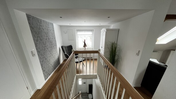 A staircase with wooden railings leading to a landing.