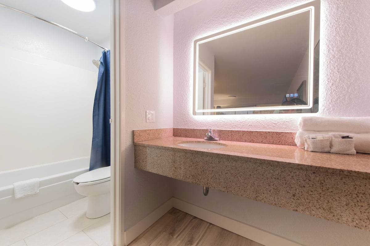 Een bad/douchecombinatie, designer toiletartikelen, handdoeken, zeep