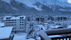 Paisaje montañoso nevado con edificios en primer plano.