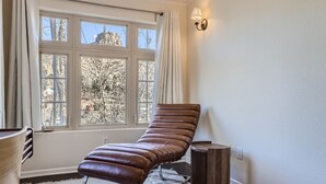 Et værelse med et vindue, en bænk, en lampe og et tæppe.