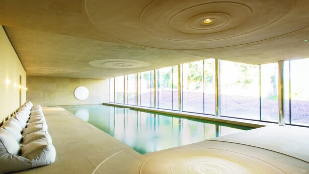 A modern indoor swimming pool with a long bench seating area and large windows. - 2 bedroom accommodation in Broughton, near Skipton (Broughton, near Skipton)
