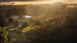 A rural landscape with a large open field, a circular pattern in the grass, and a building with a flat roof. - 2 bedroom accommodation in Broughton, near Skipton (Broughton, near Skipton)