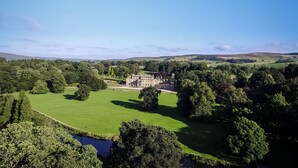 A large estate with expansive green lawns, a prominent building, and a lake. - 2 bedroom accommodation in Broughton, near Skipton (Broughton, near Skipton)