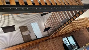 A modern interior with a sloped ceiling, wooden paneling, and a visible pool area. - Quelque Part au Calme (Beaumé)