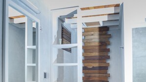 Ein modernes Badezimmer mit einer Wand aus Holzleisten, einem weißen Waschbecken und einer Toilette.
