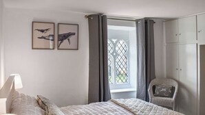 A bedroom with a bed, a chair, a wardrobe, and two framed pictures on the wall. - 2 bedroom accommodation in Burrow, near Kirkby Londsdale (Burrow, near Kirkby Londsdale)