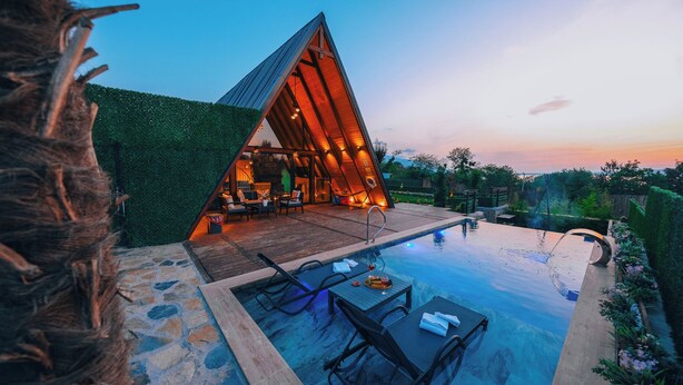 A modern villa with a triangular roof, a swimming pool, and outdoor furniture. - Boz Bungalov (Sapanca)