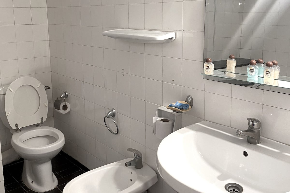 A bathroom with a toilet, bidet, and sink.