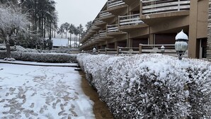 A snow-covered hotel corridor with a series of balconies and a pathway. - Hôtel Tidghine (Issaguen)