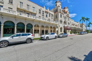 A multi-story hotel with a central courtyard, balconies, and a classic architectural style. - Bliss 1br/Pool/StepsToBeach/Dine (Palm Beach)