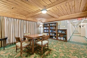 A room with a wooden ceiling, a table with chairs, a bookshelf, and a patterned carpet. - Bliss 1br/Pool/StepsToBeach/Dine (Palm Beach)