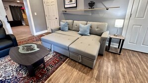 A living room with a sectional sofa, a coffee table, a side table, and a rug. - Convenient 1 BR close southside (Pittsburgh)
