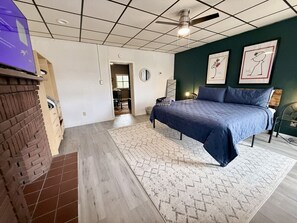 A bedroom with a bed, a ceiling fan, a brick wall, and a window. - Convenient 1 BR close southside (Pittsburgh)