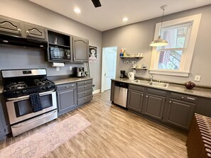 A modern kitchen with grey cabinets, stainless steel appliances, and a wooden floor. - Convenient 1 BR close southside (Pittsburgh)