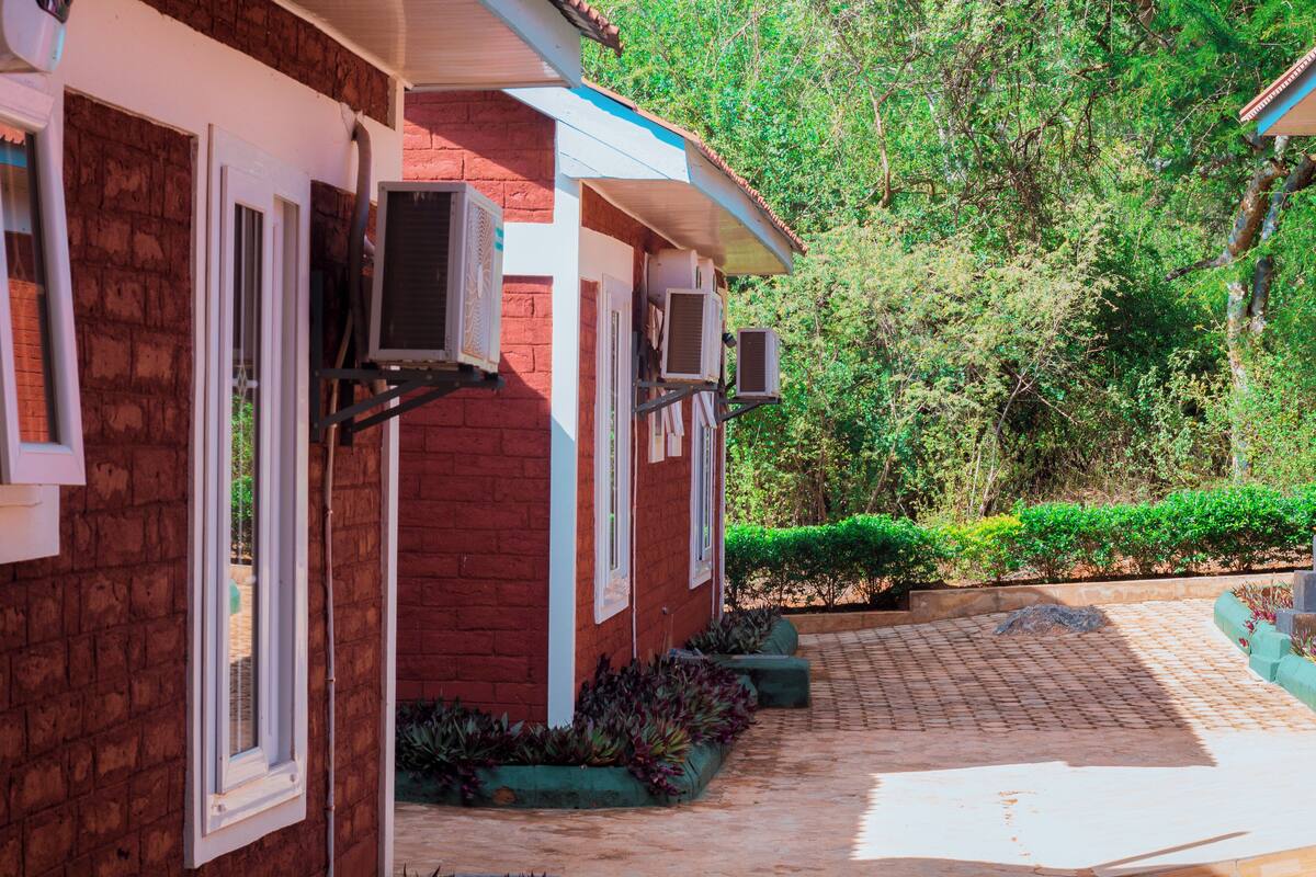 A red brick building with multiple air conditioning units mounted on the exterior wall.