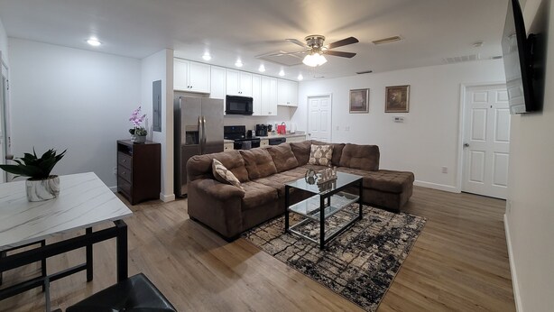 A modern living room with a sofa, coffee table, and dining table.