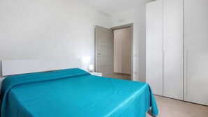 A bedroom with a bed, a nightstand, and a wardrobe.