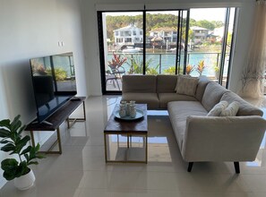 Relax in this stylish living room with a large flat-screen TV, comfortable sofa, and balcony access to a marina view.