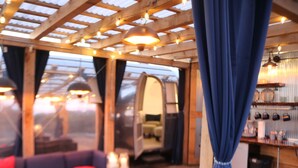 A cozy room with a sofa, a table with candles, and a mirror. - Hocking Hills Airstream & Outdoor Living (McArthur)