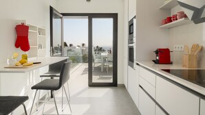 Cozinha moderna com área de jantar, vista da cidade e varanda.