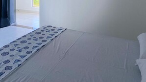 A bedroom with a bed, an air conditioning unit, a window with curtains, and a view of the beach. - BL Maria Bonita Pousada (Maragogi)