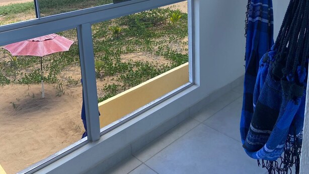 A room with a large window overlooking a beach. - BL Maria Bonita Pousada (Maragogi)