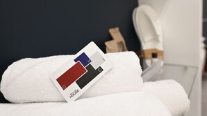 Un asciugamano bianco con un campionario di colori su un letto in una camera d'albergo.