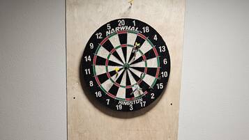 A dartboard mounted on a wooden board against a textured wall.