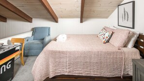 A bedroom with a bed, a chair, a desk, and a framed plant on the wall. - Blue Ridge Mountain VIEWS | Pet Friendly | Near Boone & Blowing Rock (Boone)