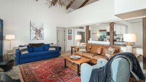 A living room with a blue sofa, a brown sofa, a coffee table, and a red patterned rug. - Blue Ridge Mountain VIEWS | Pet Friendly | Near Boone & Blowing Rock (Boone)
