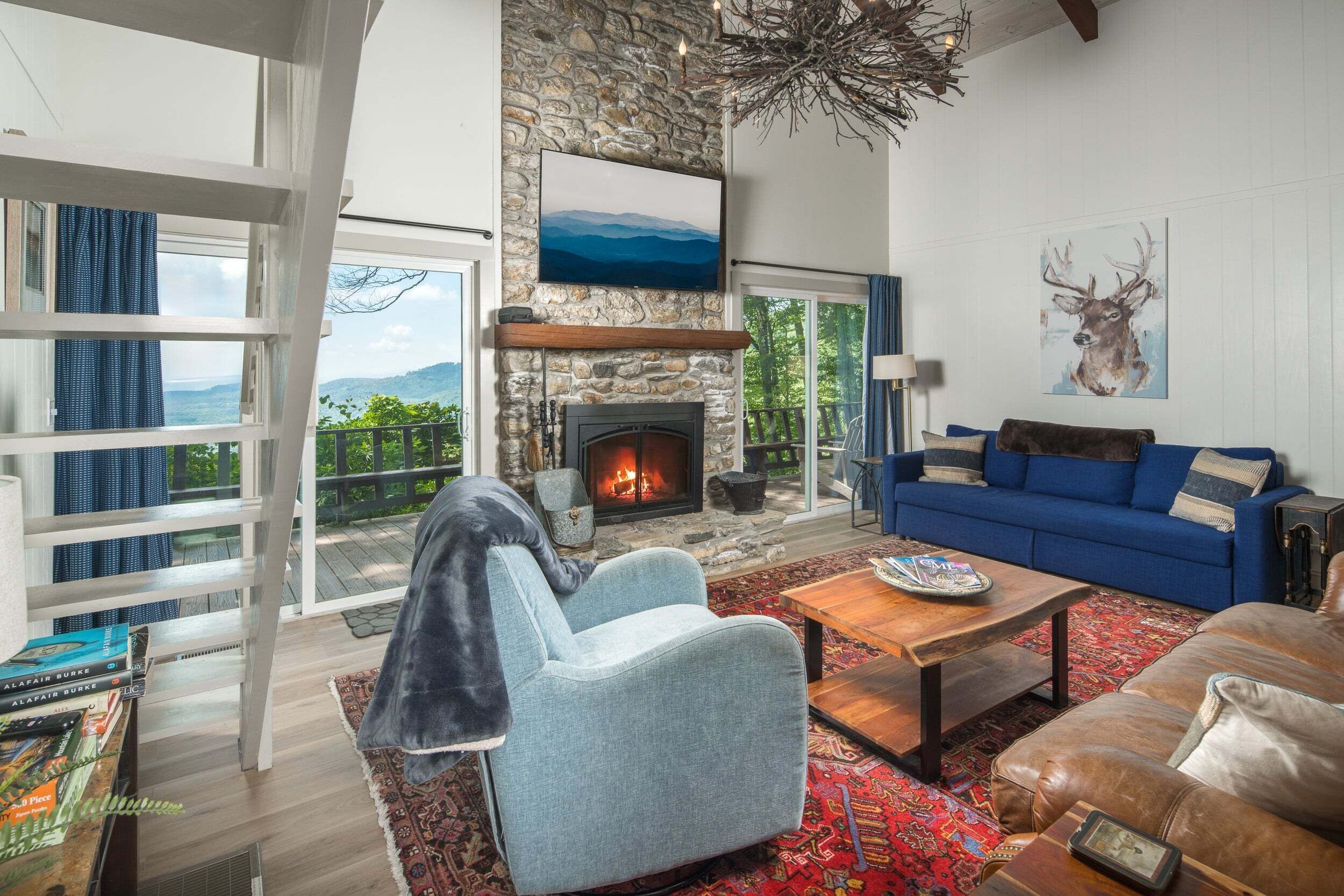 A cozy living room with a fireplace, a blue sofa, and a stone wall.
