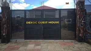 A gated entrance with the sign "DEXOC GUEST HOUSE" on a black gate. - Dexoc Guest House  (Oduman)