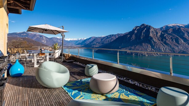 A terrace with outdoor seating, a table, and a view of a lake and mountains. - Xino Terrace View by Interhome (Fonteno)
