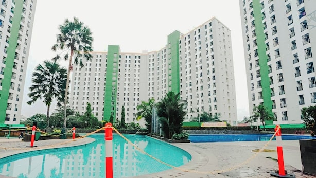 Une piscine entourée d’immeubles d’habitation de grande hauteur.