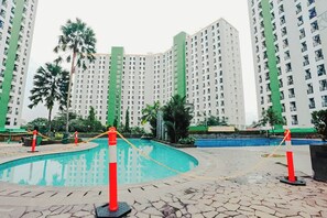 A swimming pool surrounded by high-rise residential buildings. - Aurora Rooms at Green Lake View Apartment (South Tangerang)