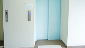 Un ascenseur doté d’un écran numérique et d’un panneau de commande avec des boutons indiquant la direction.