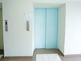 Um elevador com visor digital e painel de controle com botões de direção.