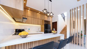 Una cocina moderna con muebles de madera, encimera blanca y una isla integrada con taburetes de bar.