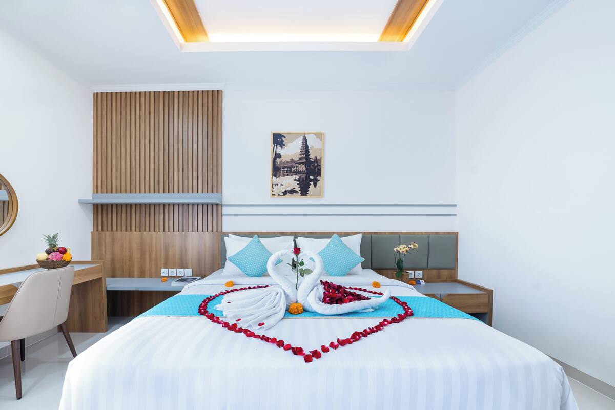 Een moderne hotelkamer met een opgemaakt bed, een bureau en een stoel.