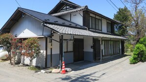 A traditional Japanese house with a tiled roof, a covered entrance, and a gravel driveway. - 5 minutes from Azumino Interchange! Ideal for families and groups staying together! A private old house that can accommodate up to 14 people in 5 bedrooms! Barbecue available on the terrace! (AZUMINO-CITY TOYOSHINA TAZAWA)
