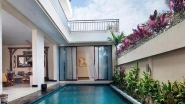 A swimming pool with a wooden deck, a covered patio area, and a balcony with plants. - Soleil Suites Petitenget By the jero 18 (Keroboken Kelod)