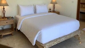 A bedroom with a large bed, two bedside tables, and a painting on the wall. - Soleil Suites Petitenget By the jero 18 (Keroboken Kelod)