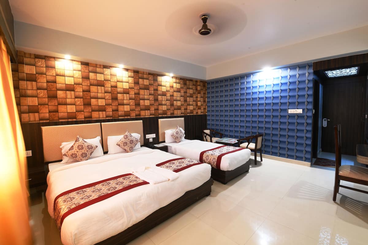 Ein Hotelzimmer mit zwei Betten, einem Schreibtisch und einem Stuhl.