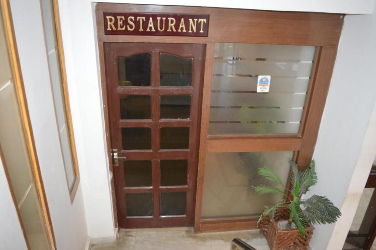Une porte en bois avec un panneau en verre dépoli et une enseigne indiquant « RESTAURANT » au-dessus.