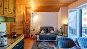 A cozy room with a bed, a small table, a chair, a coffee machine, and a view through a window. - Chaberton Romantic Retreat Ski In Ski Out, Claviere, Italy (Claviere)