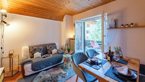 A cozy room with a bed, a dining table, a chair, a lamp, and a window. - Chaberton Romantic Retreat Ski In Ski Out, Claviere, Italy (Claviere)