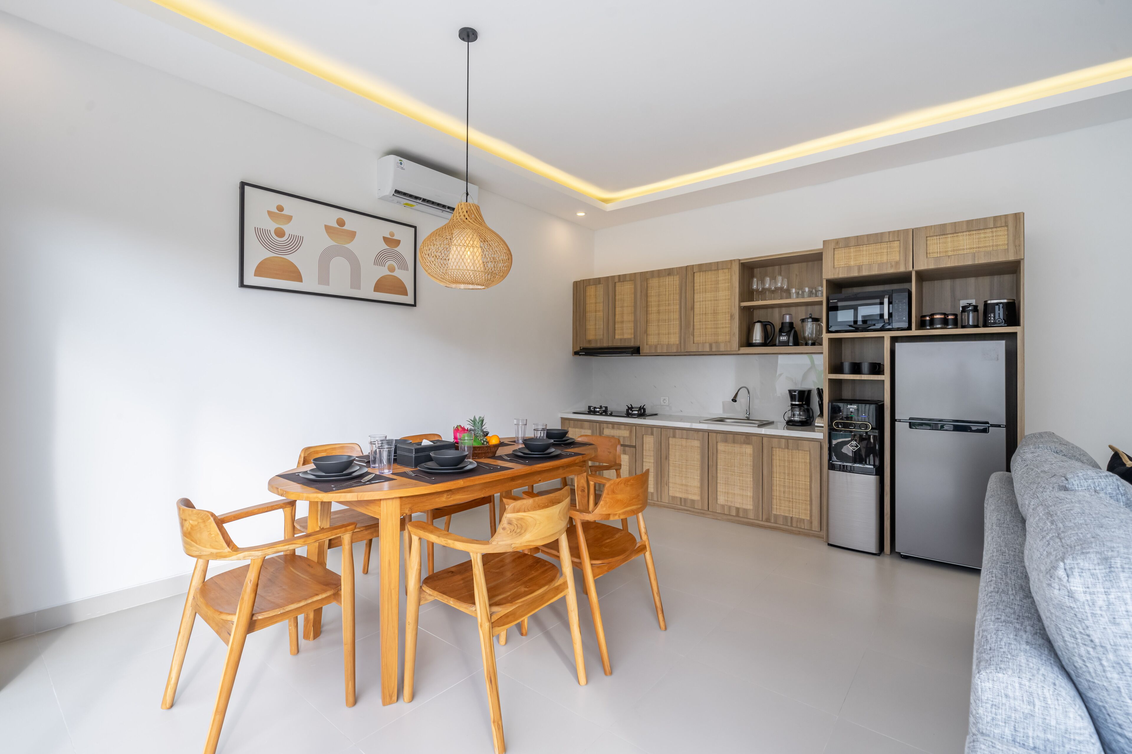 A modern kitchen with wooden cabinets, a built-in stove, and a stainless steel refrigerator.