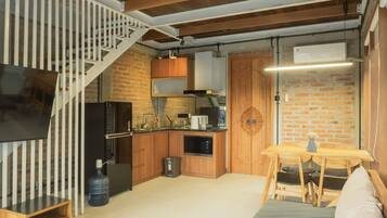A compact kitchen with wooden cabinets, a built-in stove, and a refrigerator.